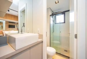 Un baño blanco con lavabo y ducha. en Flat moderno e aconchegante no Ecoville, en Curitiba 29 fotos más