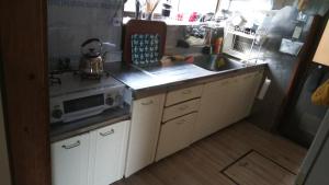 a kitchen with a sink and a microwave at 幕山ハウス in Yugawara +1 photo