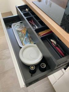 eine Schublade in einer Küche mit einem Teller darin in der Unterkunft Nid du Merle, Pessac in Pessac