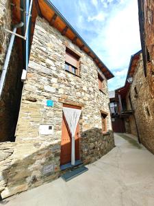 kamienny budynek z drzwiami na boku w obiekcie Casa el Tejo w mieście San Cristóbal de Valdueza