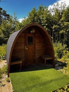 VirtsuAnniksson Tiny House的一间带门和两张长凳的小木棚