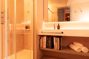 a bathroom with a shower and a book shelf with books at chic&basic Reding in Barcelona +24 photos
