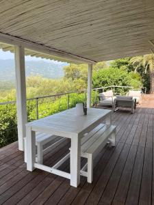 a white picnic table on a wooden deck at Torraccia in Porto-Vecchio