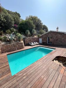 a swimming pool on a wooden deck with a swimming poolvisor at Torraccia in Porto-Vecchio