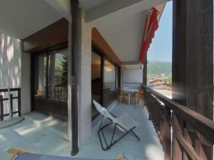 a balcony of a house with a chair and a table at Appartement au centre - 3 pièces, 6 personnes, ascenseur - FR-1-241-222 in Le Grand-Bornand