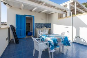 a patio with a table and chairs and a blue door at The twins Rooms in Marettimo 2 in Marettimo