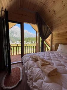 una camera da letto con un letto e una grande finestra di BUJTINA IZET SELIMAj a Valbona
