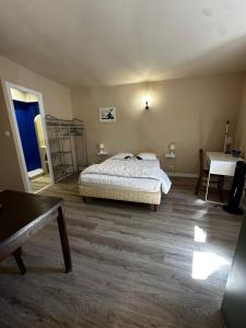 a bedroom with a bed and a table and a desk at Studio 4 Aux volets bleus in Aulus-les-Bains