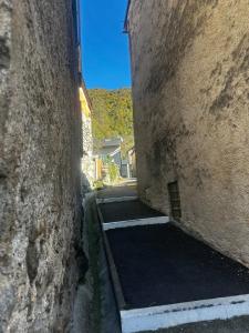 an alley between two large stone buildings at Studio 4 Aux volets bleus in Aulus-les-Bains