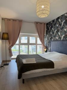 a bedroom with a bed and a large window at Escale moderne et chaleureux in Auxerre