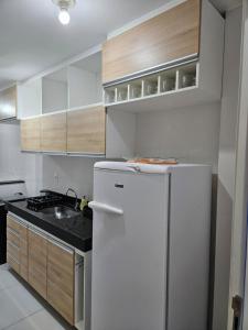una cucina con un frigorifero bianco e un lavello di Apartamento em Cabo Frio a Cabo Frio