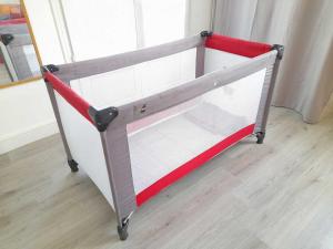 ein kleines weiß-rotes Bett mit einem roten Band in der Unterkunft Nid du Merle, Pessac in Pessac