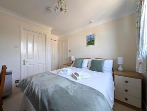 a bedroom with a bed with two towels on it at 19 Seaview Bay - Charming Seafront Apartment on the Isle of Wight in Seaview
