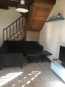 Una sala de estar con un sofá y una escalera. en Etape cocooning, en Villefranche-Saint-Phal 1 foto más