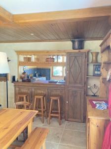 a kitchen with wooden cabinets and stools in a room at L'Evasion Authentique - Nature & Cheminée in Les Thuiles