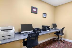 una oficina con un escritorio con dos computadoras y una impresora en Best Western White House Inn, en Bangor