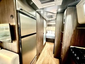 a small room with a refrigerator and a bedroom at Airstream Canyon in Orderville