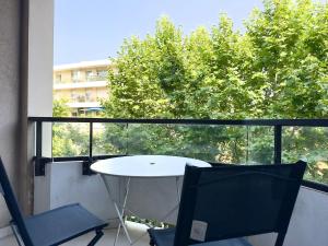 a balcony with a table and two chairs and a window at Spacious new studio and terrace in Juan-les-Pins