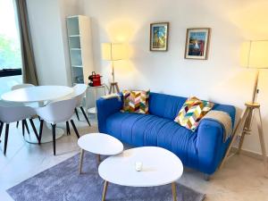a living room with a blue couch and a table at Spacious new studio and terrace in Juan-les-Pins