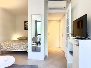 a bedroom with a bed and a television and a table at Spacious new studio and terrace in Juan-les-Pins