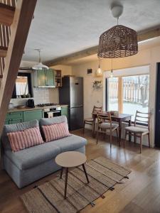 a living room and kitchen with a couch and a table at Casa iliana in Breaza de Jos +13 photos