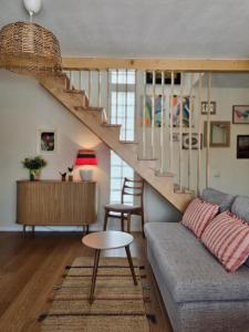 a living room with a couch and a staircase at Casa iliana in Breaza de Jos