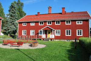 a red house with benches in front of it at Nordsjögården in Järvsö