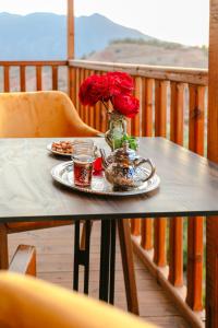 a table with a vase of roses on a balcony at Atlas Smile Retreat in Ouirgane