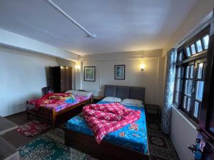 a bedroom with two beds and a window at Nembang Family homestay in Darjeeling +7 photos