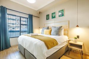 una camera da letto con un letto grande e una finestra di Elegant Emerald Stay at Ridgeton Modern Two Bedroom Apartment in the Heart of Umhlanga Ridge Sleeps 6 a Durban