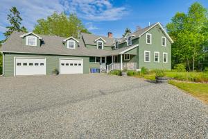 a green house with two white garage doors at 1 Mi to Acadia National Park Spacious Retreat! in Southwest Harbor