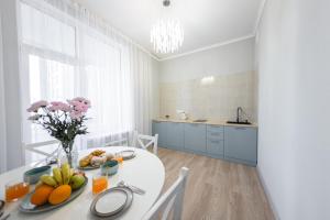 a white kitchen with a table with fruit on it at Aqzam in Zhezdi
