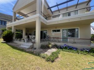 a large house with a balcony and a yard at Golfers paradise on 25th green in Hermanus