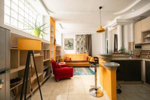 a living room with a yellow couch and a red chair at Easy Stay Apartments in Pristina