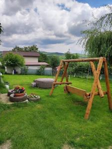a swing set in a yard with green grass at Vila Rodica in Lunca Mare