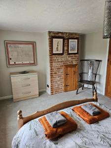 a bedroom with a bed with two towels on it at 2 Church Path in Earsham +3 photos