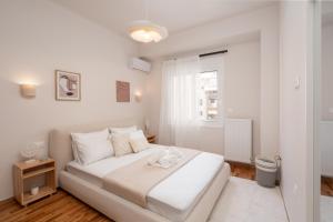 ein weißes Schlafzimmer mit einem Bett und einem Fenster in der Unterkunft RoomsByRamez -Chill Bright Stay- -Central Athens- in Athen