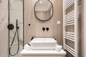 ein Badezimmer mit einem weißen Waschbecken und einem Spiegel in der Unterkunft RoomsByRamez -Chill Bright Stay- -Central Athens- in Athen + 29 Fotos