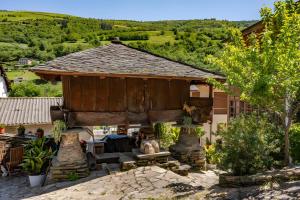 a pavilion with a table and chairs in front of a house at Puente del Narcea 3 in Cibuyo