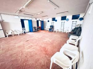 a large room with white chairs and tables in it at GW212 Gugel Waves Amazing Seaview Pool Apartments in Nahariyya +26 photos