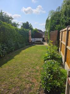 a backyard with a couch and a fence at 2 Church Path in Earsham