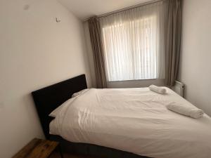 a white bed in a bedroom with a window at Modern 2 Bedroom Apartment for 6 - City Center in Brussels +1 photo