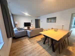 a living room with a dining room table and a couch at Modern 2 Bedroom Apartment for 6 - City Center in Brussels
