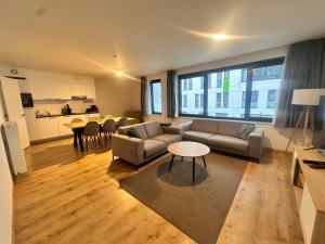a living room with a couch and a table at Modern 2 Bedroom Apartment for 6 - City Center in Brussels