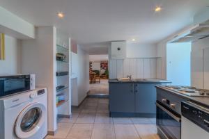 una cucina con lavatrice e asciugatrice di Le Clos de Verpierre - Appart avec Jardin a Regny