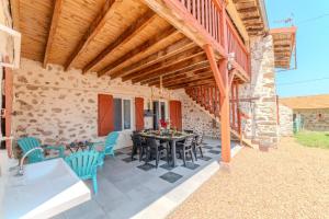 patio con tavolo e sedie sotto un soffitto in legno di Le Clos de Verpierre - Appart avec Jardin a Regny