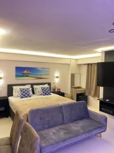 a bedroom with a large bed and a couch at Cozy Studio near Airport in Pusok