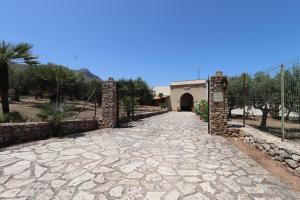 a stone walkway leading to a building with a gate at EVEN HAVEN Baglio in San Vito lo Capo +11 photos