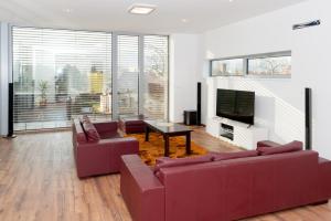 uma sala de estar com dois sofás e uma televisão em Villa Ľadoveň LUXUSNÝ APARTMÁN 124m2 em Martin