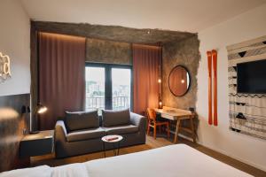 una camera d'albergo con divano, tavolo e finestra di ibis Styles Sarajevo a Sarajevo